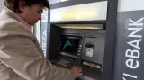 Žena vybírá peníze z bankomatu zavřené kyperské banky