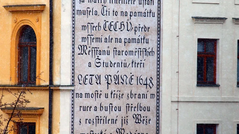 Nápis na Novotného lávce u Karlova mostu: Poutníče, postuj na místě, kde zuřivost Šwédů za wálky třicetileté ustáti musela. Čti to na památku wssech ČECHŮ, přede wssemi ale na památku Měssťanů staroměstských a Študentů, kteří LETA PÁNĚ 1648 na mostě u kříže zbraní w ruce a hustou střelbou z rozstřílené již Wěže mostecké a Wodárny útok Šwédů hrdinsky odrazili.