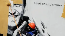 Pracovník zamázává v Petrohradu graffiti Navalného s nápisem „ hrdina nové doby“.