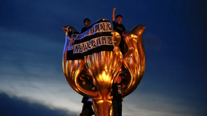 Kritické nápisy na zlaté soše upomínající k výročí