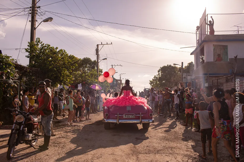 Nominace na vítěznou fotografii v kategorii SOUČASNÉ PROBLÉMY. Diana Markosian, Magnum Photos – Kubánka Pura projíždí v růžovém kabrioletu čtvrtí Havany, aby oslavila patnácté narozeniny. Ty jsou podle tradice označovány za přechod z dětství do ženství