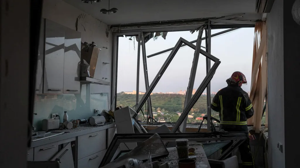 Záchranář v kyjevském bytě poškozeném ruským dronovým útokem