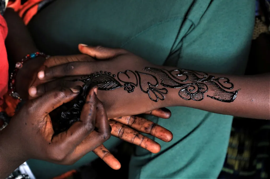 Jednadvacetiletá Bintou Diarra zdobí hennou ruce kamarádky v Abidžanu na Pobřeží slonoviny