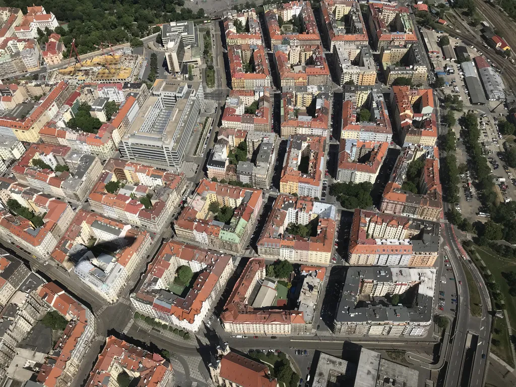 Parkhotel, Veletržní palác, Strossmayerovo náměstí, zástavba domů na Letné a stín vzducholodi na jejich střechách.