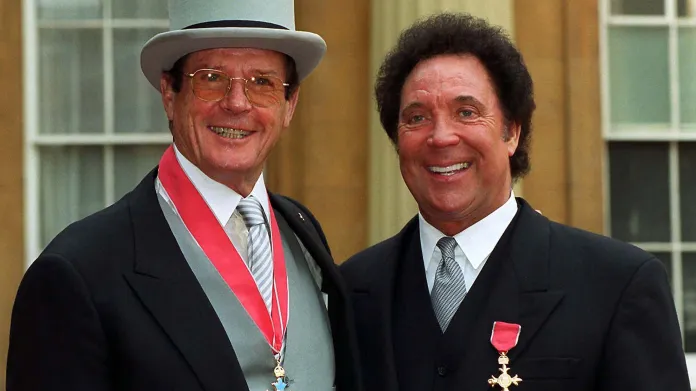 „James Bond“, tedy herec Roger Moore a Tom Jones pózují v Buckinghamském paláci poté, co od královny získali Řád britského impéria