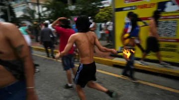 Protestující běží s Molotovovým koktejlem