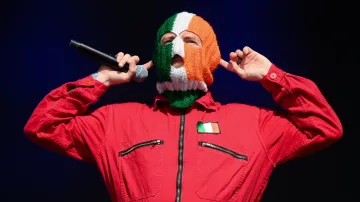 DJ Provai z Kneecap, s kuklou v barvách irské vlajky