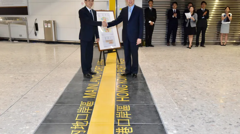 Zástupci Hongkongu a pevninské Číny u linie oddělující čínskou a hongkongskou část nádraží