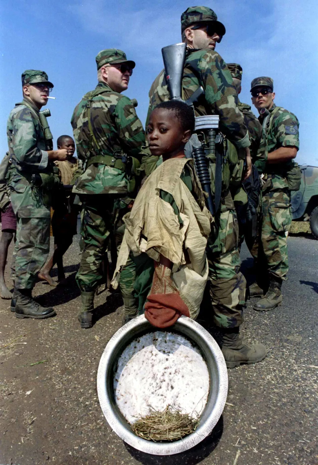 Rwandská holčička čeká na vodu před americkými vojáky z 512. zásobovací jednotky, která má za úkol zřídit rozvod vody v uprchlickém táboře Kibumba