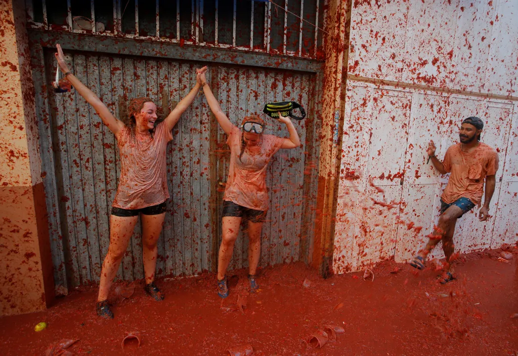 Účastníci v ulicích potřísněných rozmačkanými rajčaty během každoročního festivalu „Tomatina“ ve španělském městě Bunol v blízkosti Valencie