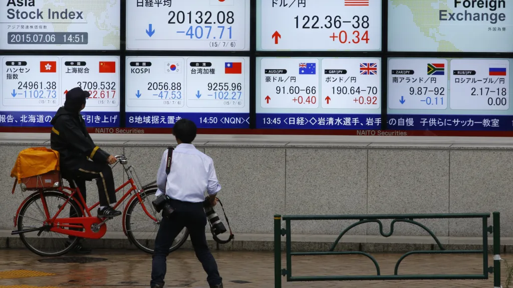 Lidé v Tokiu sledují vývoj akciových indexů, které po řeckém referendu zaznamenaly pokles