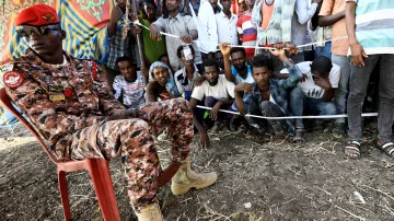 Súdanský voják hlídá dodávku humanitární pomoci z potravinového programu OSN v táboře Fashaga na hranici Súdánu s Etiopií