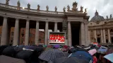 Věřící na Svatopetrském náměstí sledují shromáždění kardinálů