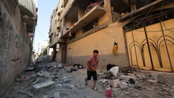 Palestinský chlapec běží kolem místa, kde izraelský útok zasáhl bytový dům v Gaze (20. června 2026)