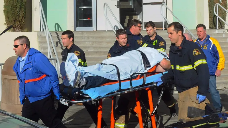 Záchranáři odvážejí postřeleného studenta