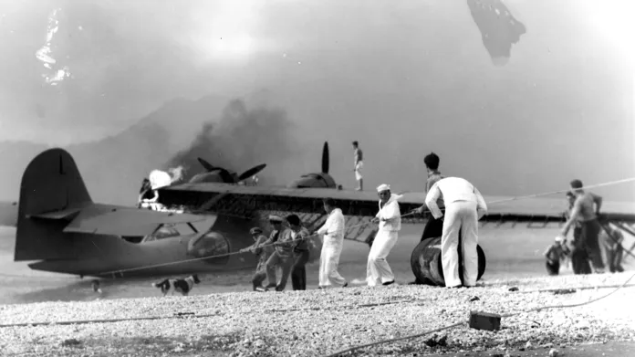 Američtí námořnící se pokoušejí zachránit zasažený obojživelný letoun na námořní letecké základně v zálivu Kaneohe