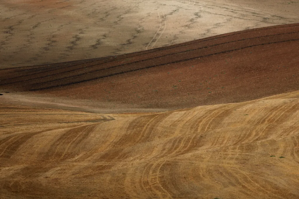 Stopy od zemědělských strojů po sklizni v období sucha nedaleko Malagy na jihu Španělska.