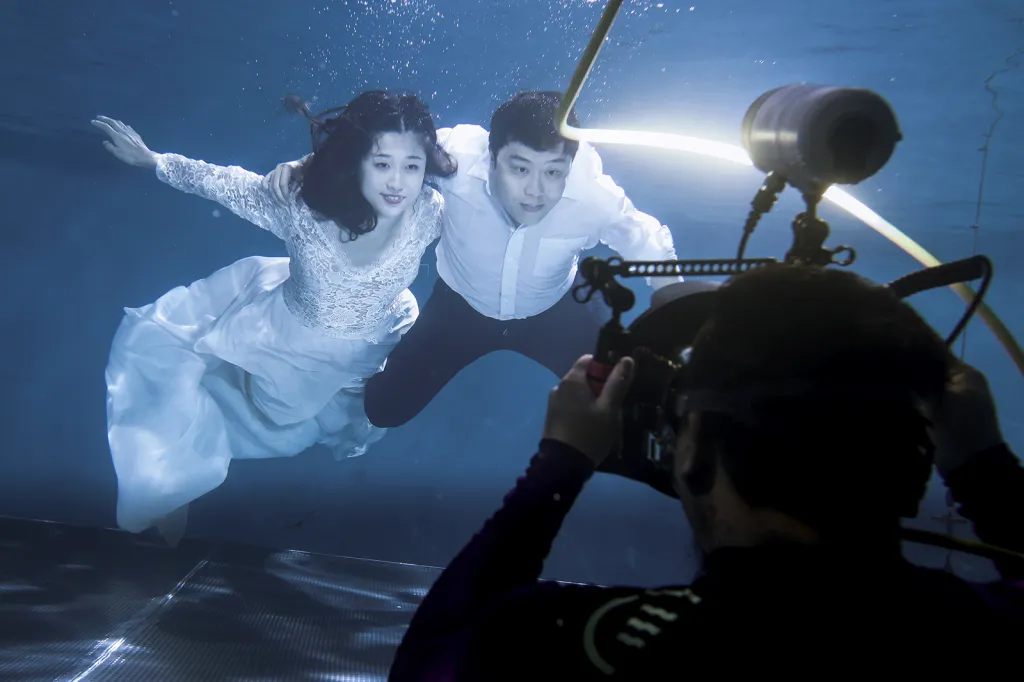 Novomanželé při své svatební fotografii v podvodním fotografickém studiu v čínském Pekingu