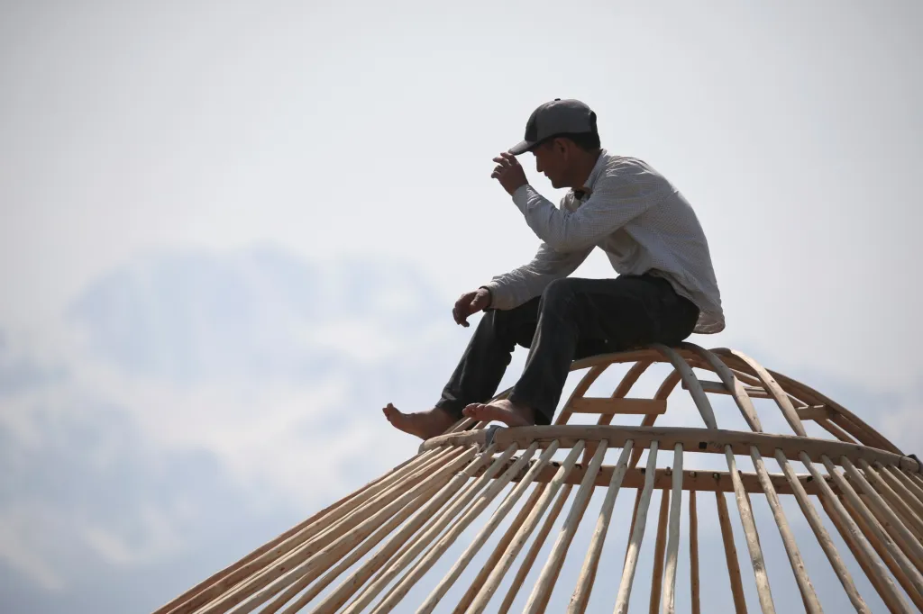 Jeden ze stavitelů mobilních příbytků odpočívá po dokončení střechy