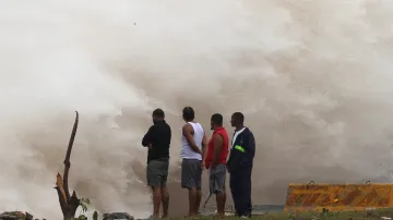 Lidé stojí před vlnami narážejícími na pobřeží Dominikánské republiky, které byly vyvolány nedalekým hurikánem Beryl