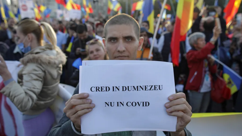 Rumunský protestující s nápisem: „Věřím v Boha, ne v covid“