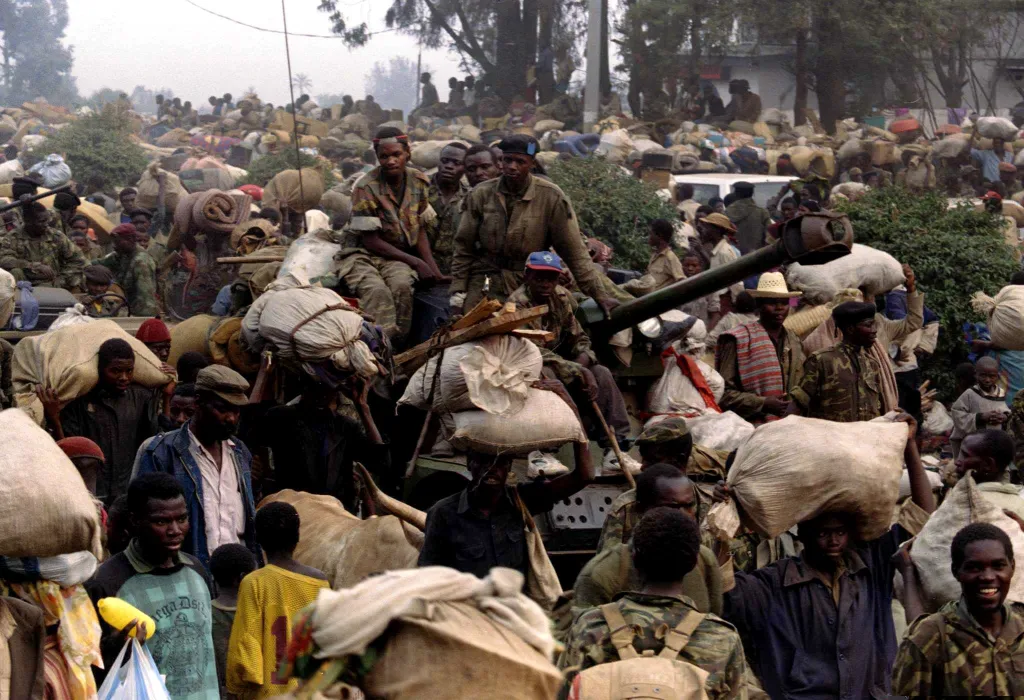 Rwandští vládní vojáci na tanku vybaveném devadesátimilimetrovým kanonem prchají s civilisty před postupujícími silami RPF 17. července 1994. Rebelové s RPF postupují směrem k hraničnímu městu Gicenyi, kde vytlačují civilisty do exilu