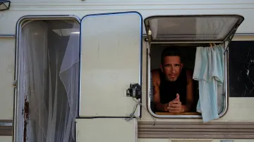 Gabriel Pizarro z Argentiny pózuje pro fotografii přes okno karavanu, ve kterém žije na Ibize