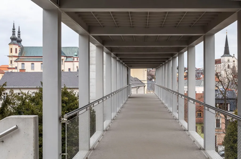 Subtilní ocelovou konstrukci lávky podpírají masivní pilíře z železobetonu. Převýšený pylon výtahu je v ose původního schodiště a nese vlastní konstrukci lávky. Jednoduchý charakter stavby oživují grafiky Ivany Šrámkové