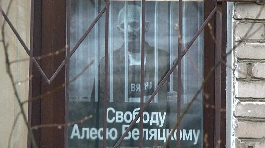 Fotka Alese Bjalackého za oknem organizace Vjasna