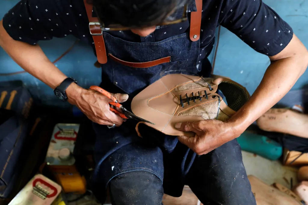 Švec vyrábí ručně boty na workshopu v indonéském Bandungu. Zajímavostí je, že k tomu využívá kůži z kuřat