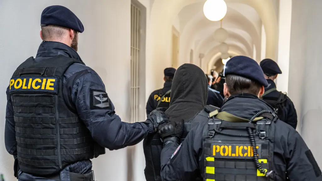 Eskorta přivádí k vazebnímu řízení u Okresního soudu mladíka obviněného z vraždy dvou žen (snímek je z 21. února 2025)