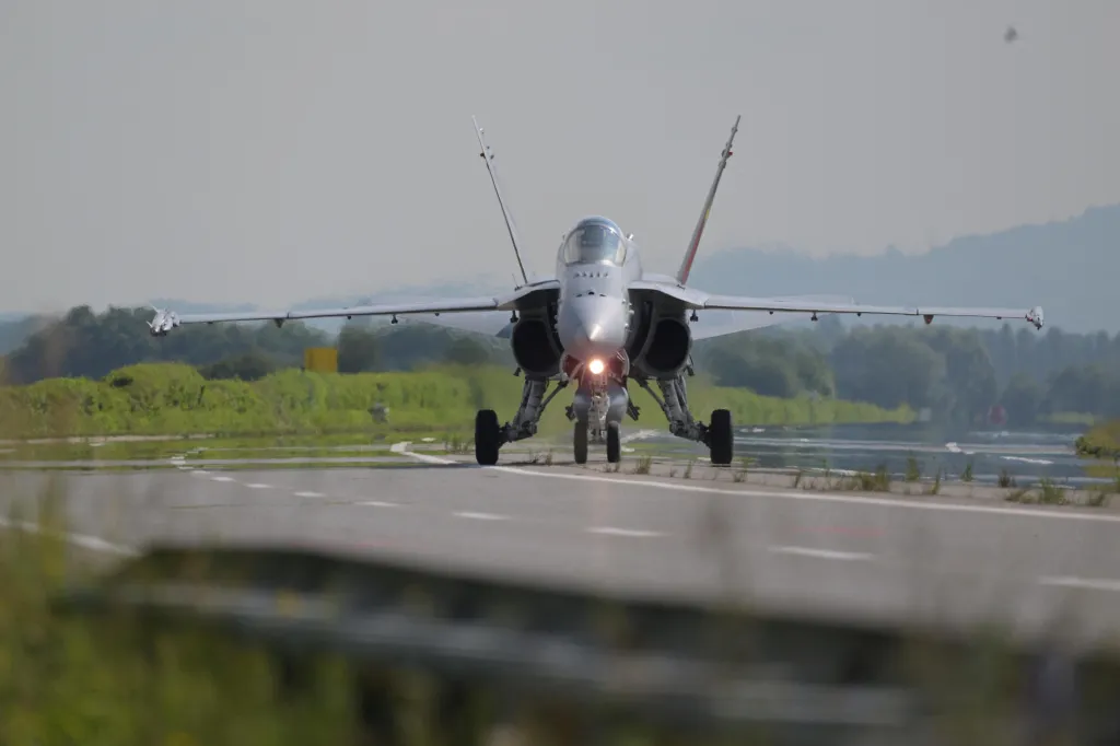 Stíhačka F/A-18 švýcarského letectva přistává na dálnici během cvičení Alpha Uno v Payerne