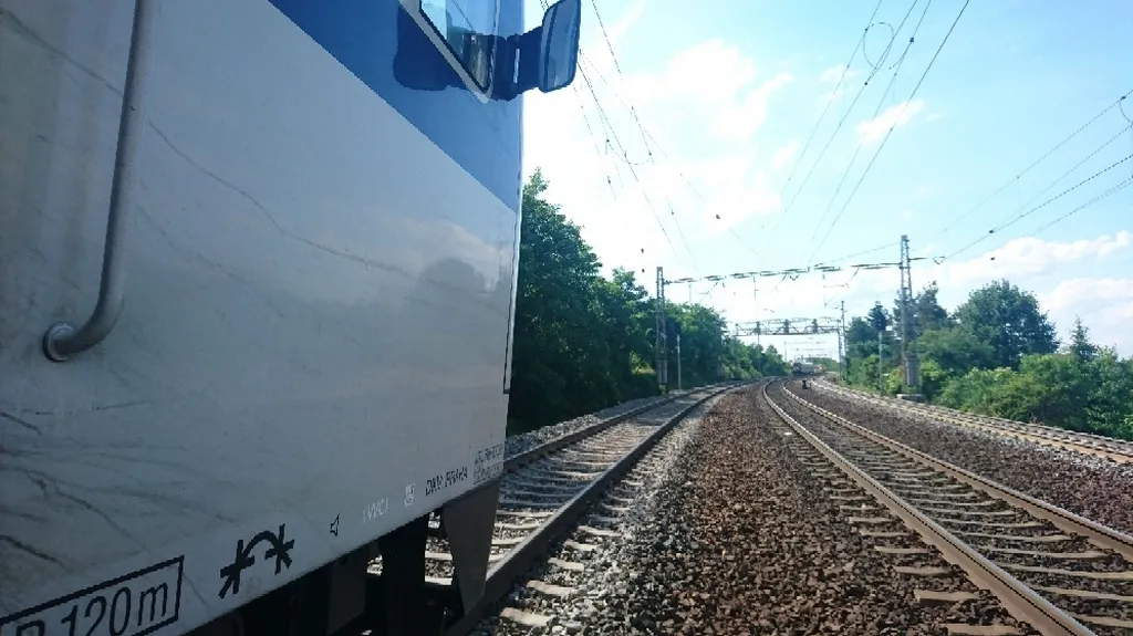 Pohled z osobního vlaku, v dálce zastavená souprava Leo Express