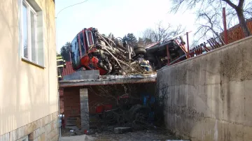 Prázdný tahač na dřevo havaroval na střechu přístavby