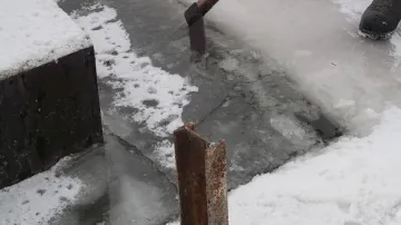 Sekání ledu na hladině rybníka