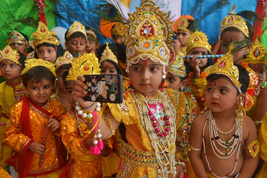 Žáci první třídy indické školy v Rádžahstánu v kostýmech hinduistického boha Krišny během festivalu Janmashtami, který oslavuje výročí jeho narození