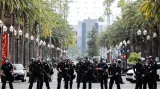 V řadách připravená policie hlídá účastníky demonstrace v americkém Anaheimu v Kalifornii