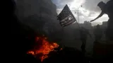Palestinští demonstranti se chystají spálit americkou vlajku během střetů s izraelskou policií poblíž židovské obce Beit El nedaleko Ramalláhu den po prohlášení Donalda Trumpa o uznání Jeruzaléma hlavním městem Izraele.