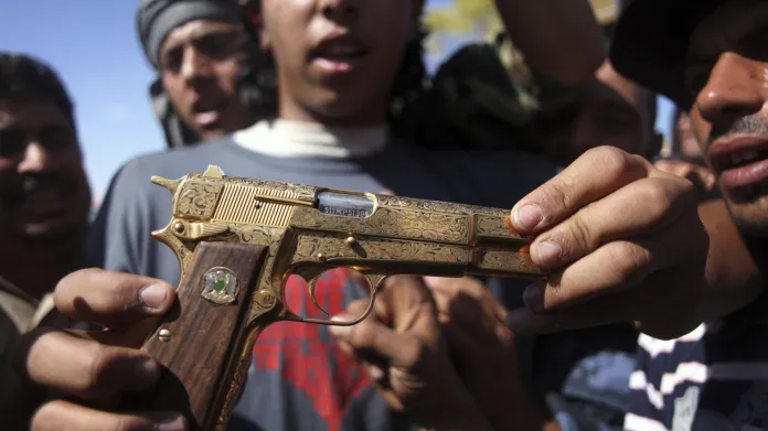 Jeden z povstalců drží zlatou pistoli, která měla údajně patřit zabitému Kaddáfímu