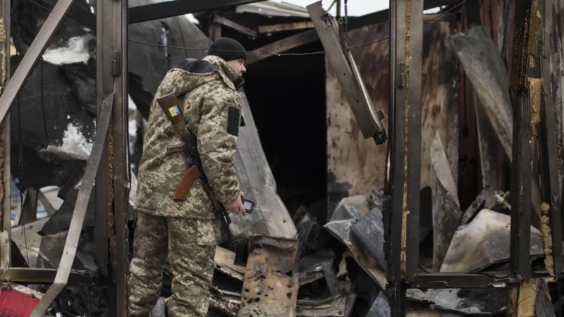 Voják prohledává sutiny v Mariupolu