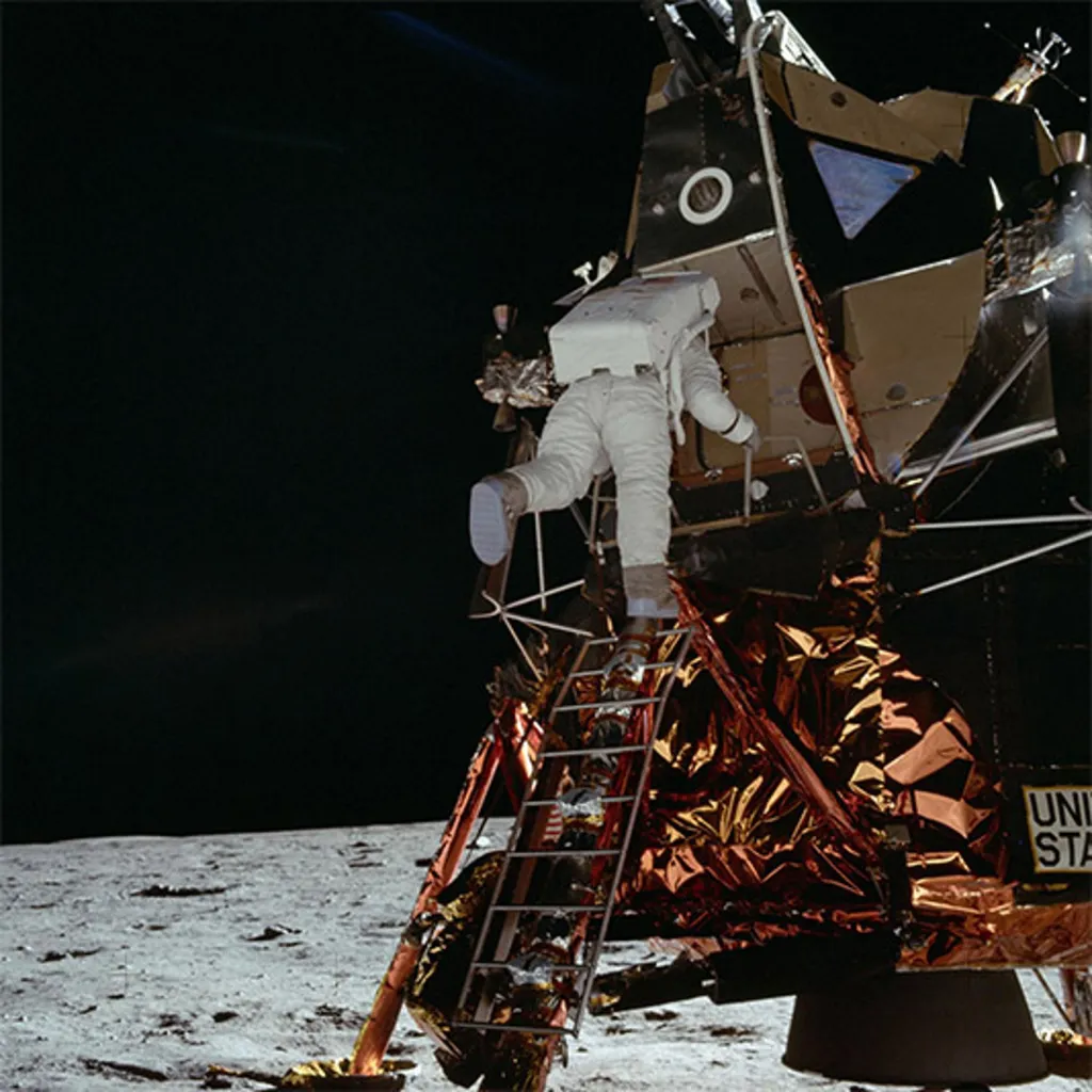 Edwin E. Aldrin Jr. sestupuje z LM „Eagle“ před první procházkou po Měsíci. Tato fotografie byla pořízena astronautem Neilem A. Armstrongem