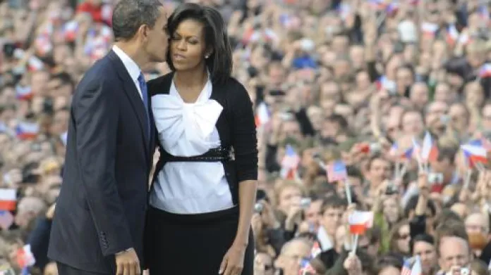 Americký prezident Barack Obama líbá svou ženu Michelle před davy lidí na pražském Hradčanském náměstí.