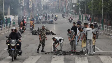 Nepálští vojáci uklízejí silnici poblíž sídla kanceláře premiéra po protestech v hlavním městě Káthmándú