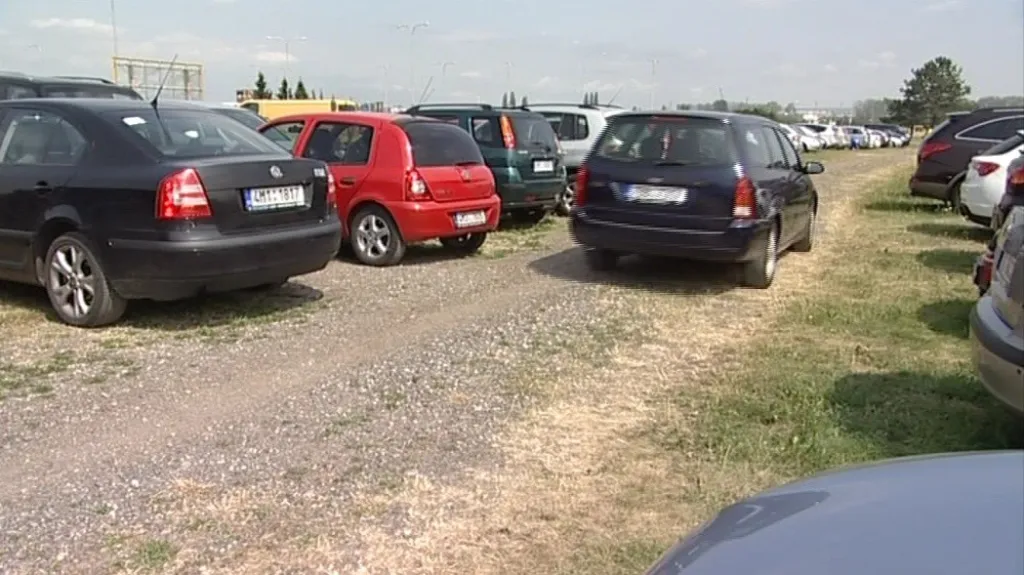Na trávě parkují stovky aut