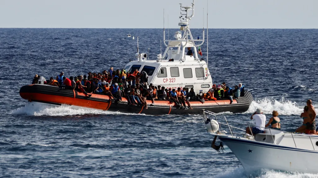 Člun italské pobřežní stráže se zachráněnými migranty u ostrova Lampedusa