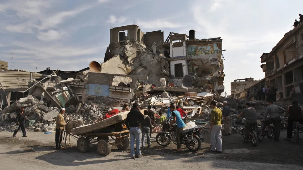 Palestinci si prohlíží dům zničený izraelským útokem