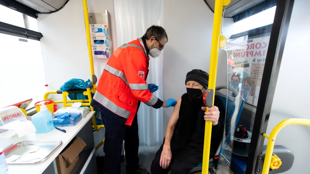 Žena dostává posilovací dávku v očkovacím autobusu v Bavorsku