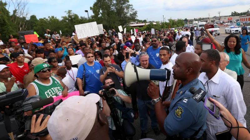 Ron Johnson promlouvá k davu demonstrantů