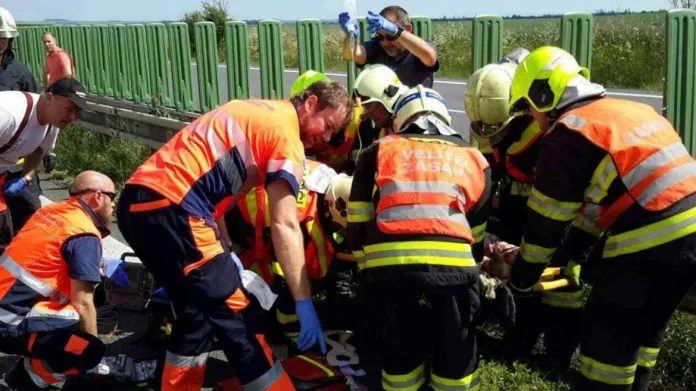 Záchranáři ošetřují zraněné po nehodě autobusu a nákladního auta na D35 u Litovle
