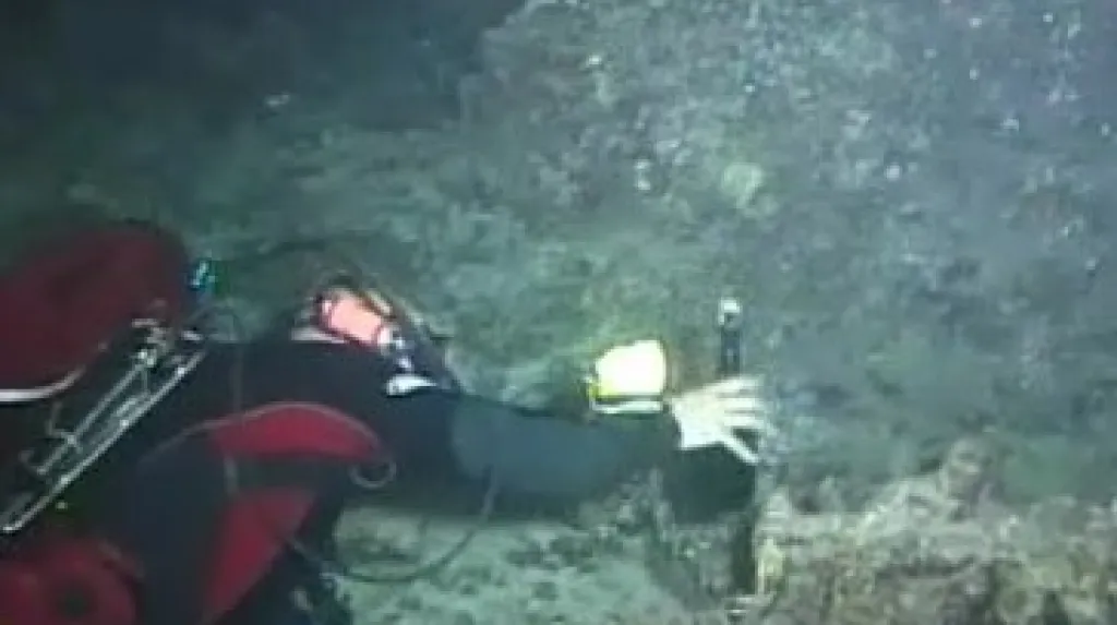 Potápěči-vinaři ukládají láhev sektu na dno moře